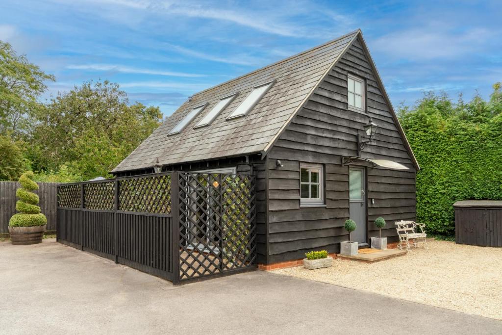 a black house with a gambrel roof at Timber Lodge in Tackley