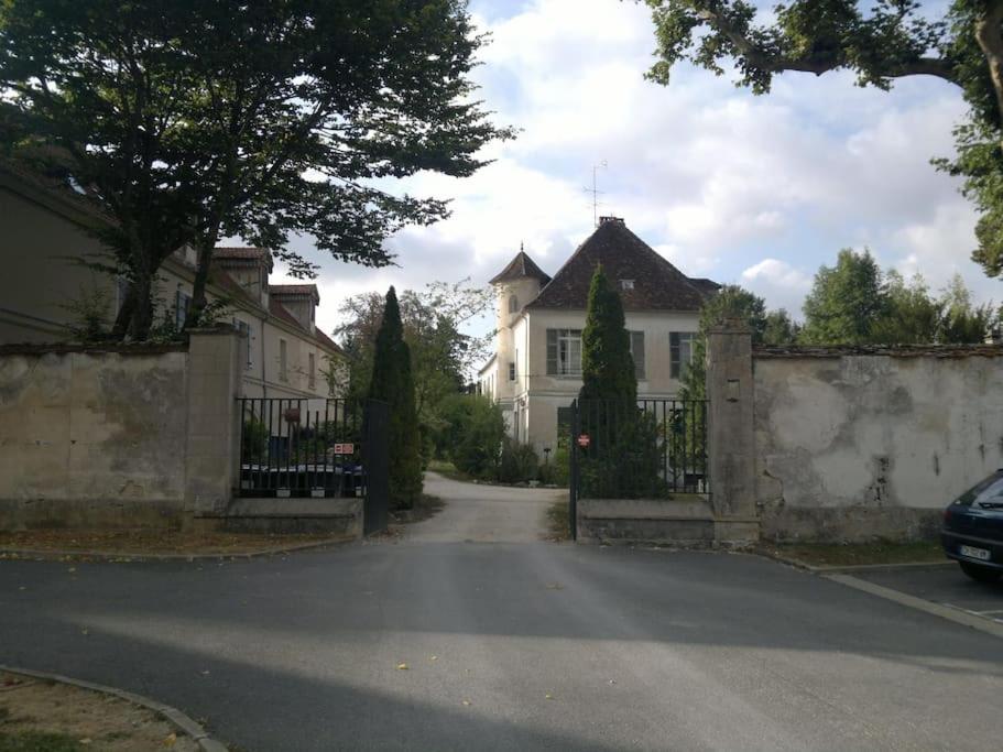 ein weißes Haus mit einem Zaun und einer Einfahrt in der Unterkunft Appartement - Paris - Champagne - Disney - Campagne - Familles 
