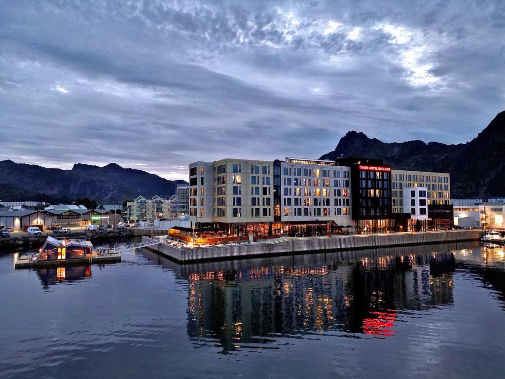 a large building sitting next to a body of water at Thon Hotel Svolvær in Svolvær