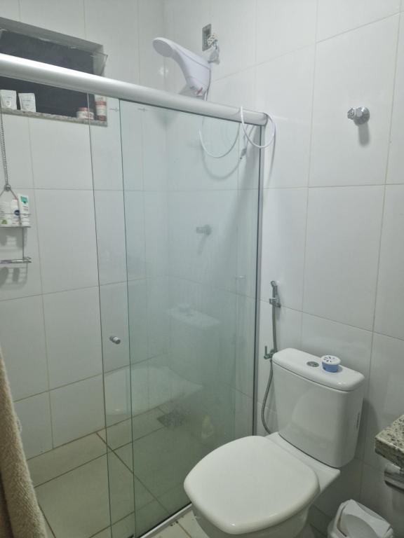 a bathroom with a toilet and a glass shower at Souza Lofts Centro Praça Tiradentes in Teófilo Otoni
