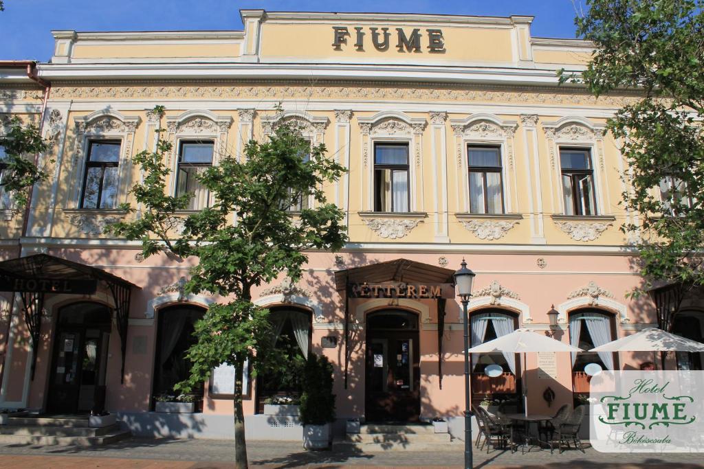 a pink building with a sign on top of it at Fiume Hotel in Békéscsaba