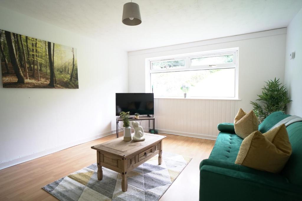 a living room with a green couch and a coffee table at Queensferry Apartment in North Queensferry
