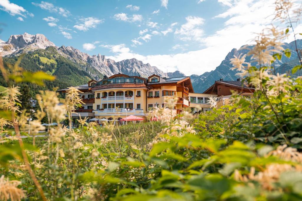 a hotel in the mountains with mountains in the background at Berg & SPA Hotel Urslauerhof in Maria Alm am Steinernen Meer