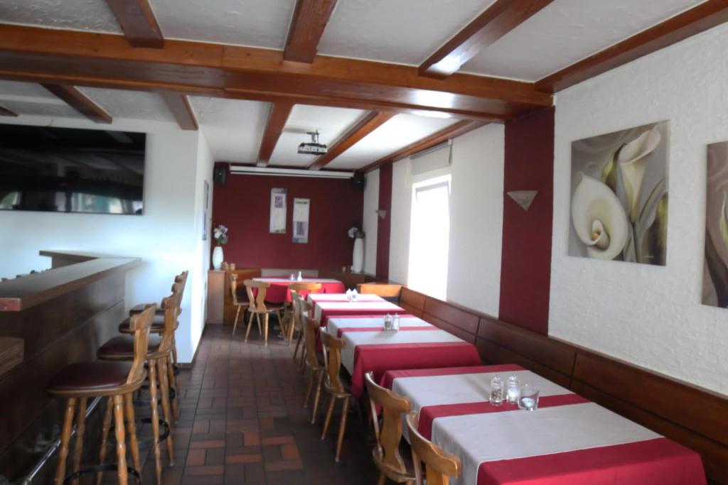 a restaurant with red and white tables and chairs at Altes Backhaus in Herzogenaurach