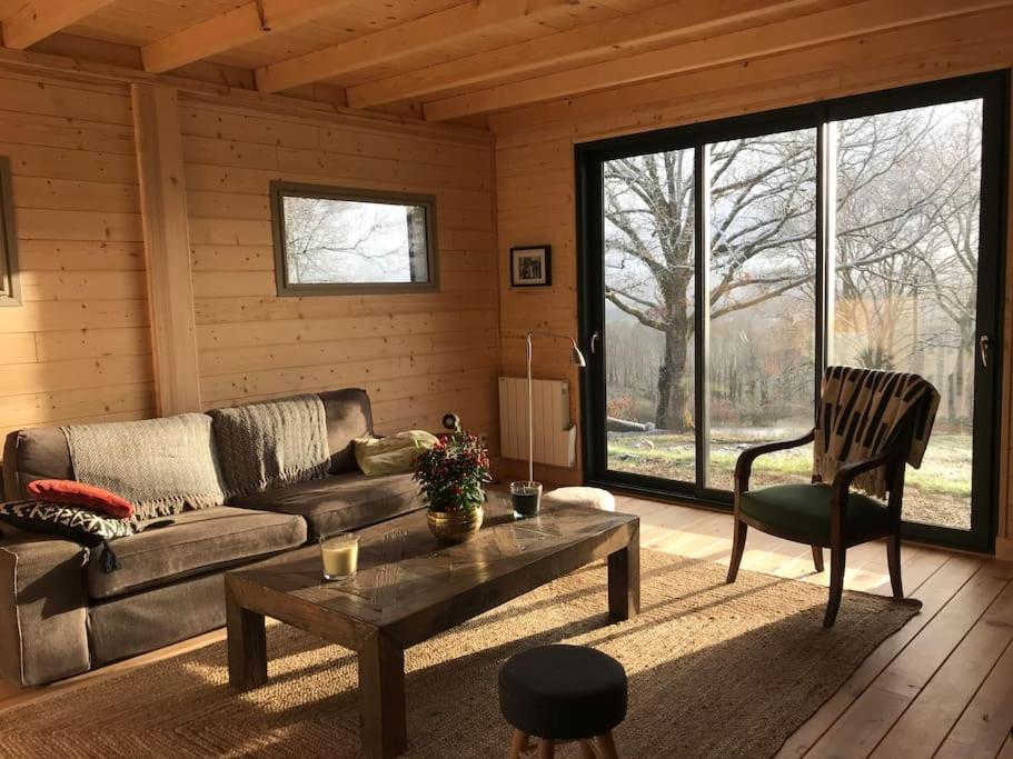 a living room with a couch and a coffee table at Maison de bois en pleine nature à 20 min de Beaune in Montceau-et-Écharnant