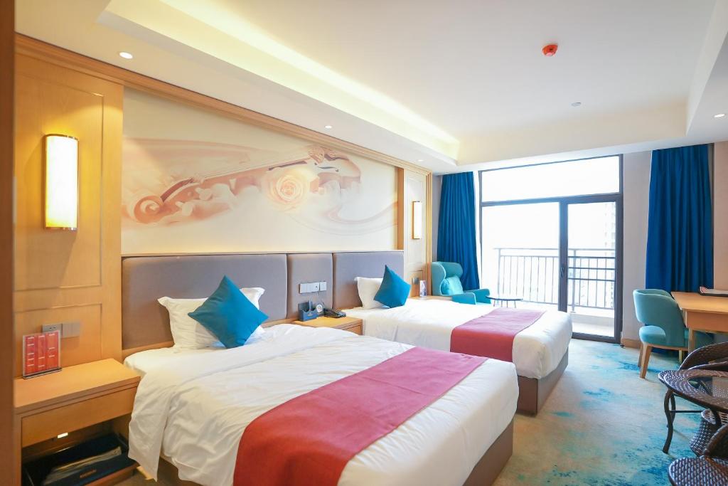 a hotel room with two beds and a desk at SENNA SUNSHINE INTERNATIONAL HOTEL in Sihanoukville