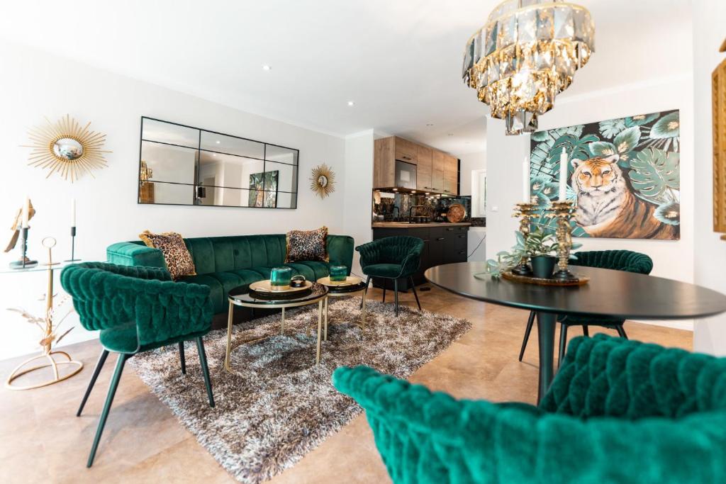 een woonkamer met groene meubels en een tafel bij Juwel am Meer - Smaragd in Bad Zwischenahn