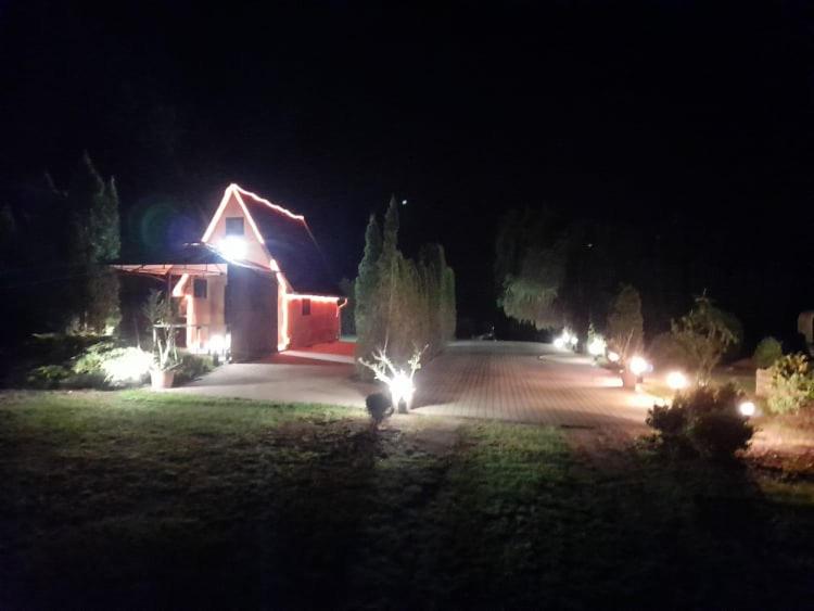 une maison éclairée dans la cour la nuit dans l'établissement Ibituba Vendéglak, à Bogács