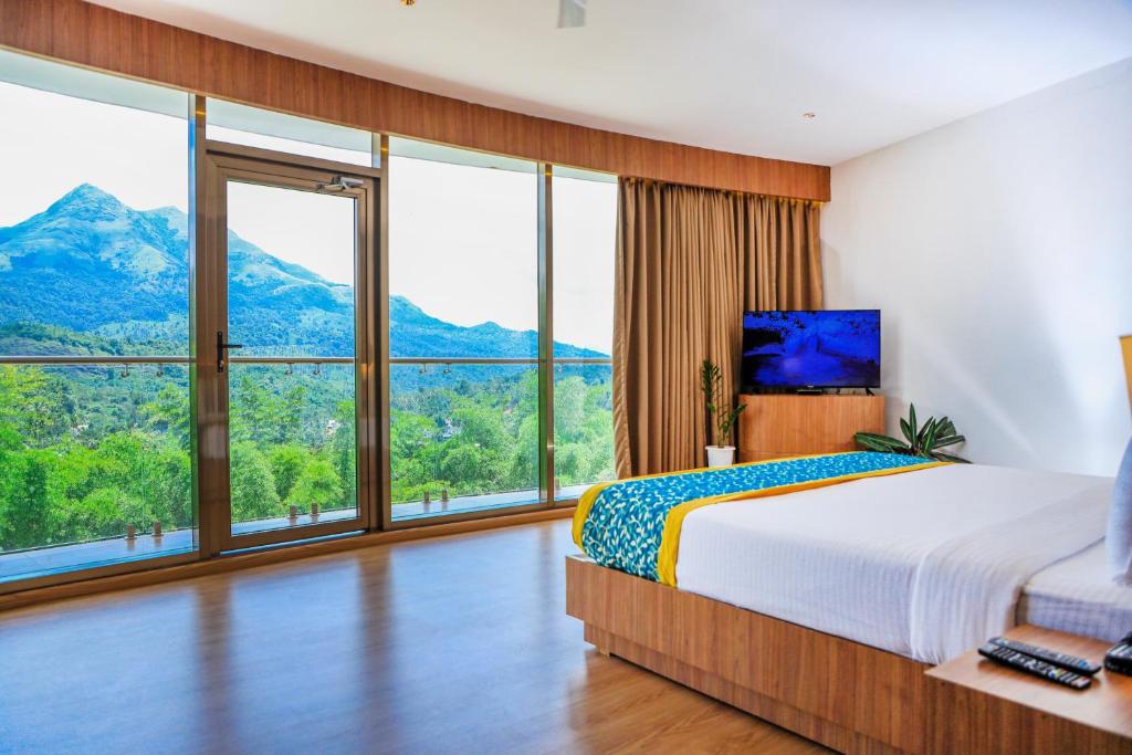 ein Schlafzimmer mit einem großen Bett und großen Fenstern in der Unterkunft Hotel Sky Sierra Wayanad in Kalpatta