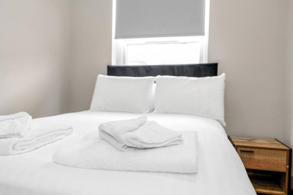 a white bed with two towels on top of it at Sleek and Stylish Converted 1Bed in Old Boiler Factory - Flat 4 in Nottingham