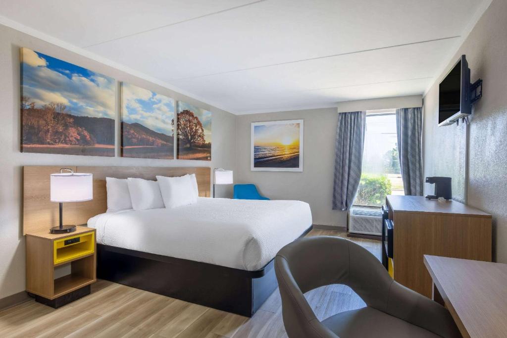 Days Inn & Suites by Wyndham Fort Bragg/Cross Creek Mall في فايتفيل: غرفة في الفندق مع سرير ومكتب