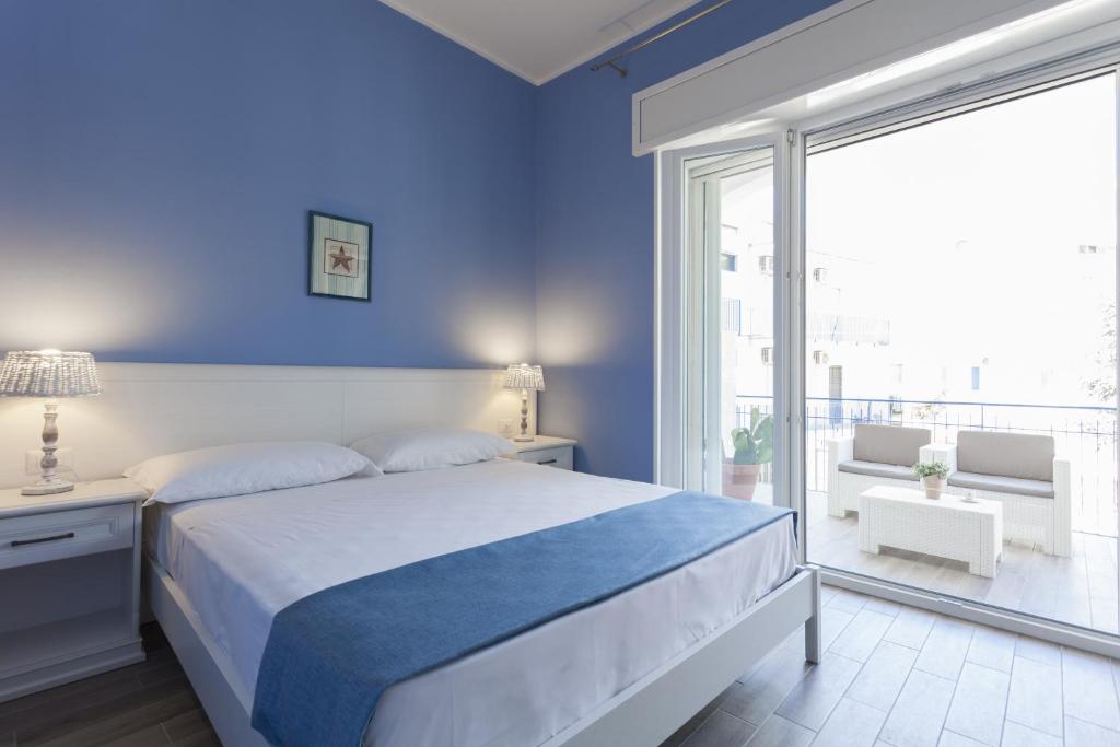 ガリポリにあるCosta Azzurra Gallipoliの青いベッドルーム(ベッド1台、大きな窓付)