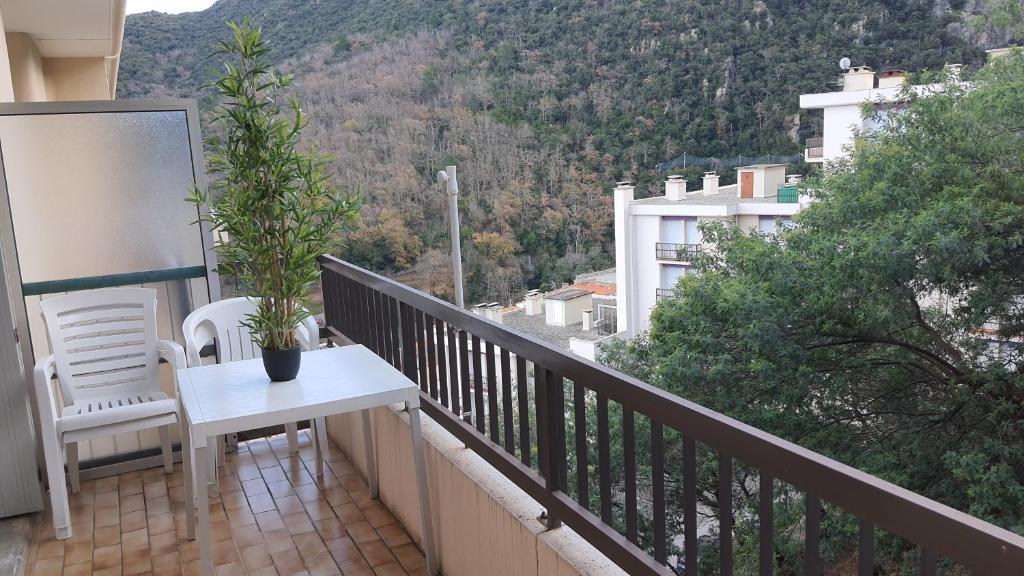 un balcon avec une table et des chaises et une vue dans l'établissement Studio Amèlie les bains, à Amélie-les-Bains-Palalda
