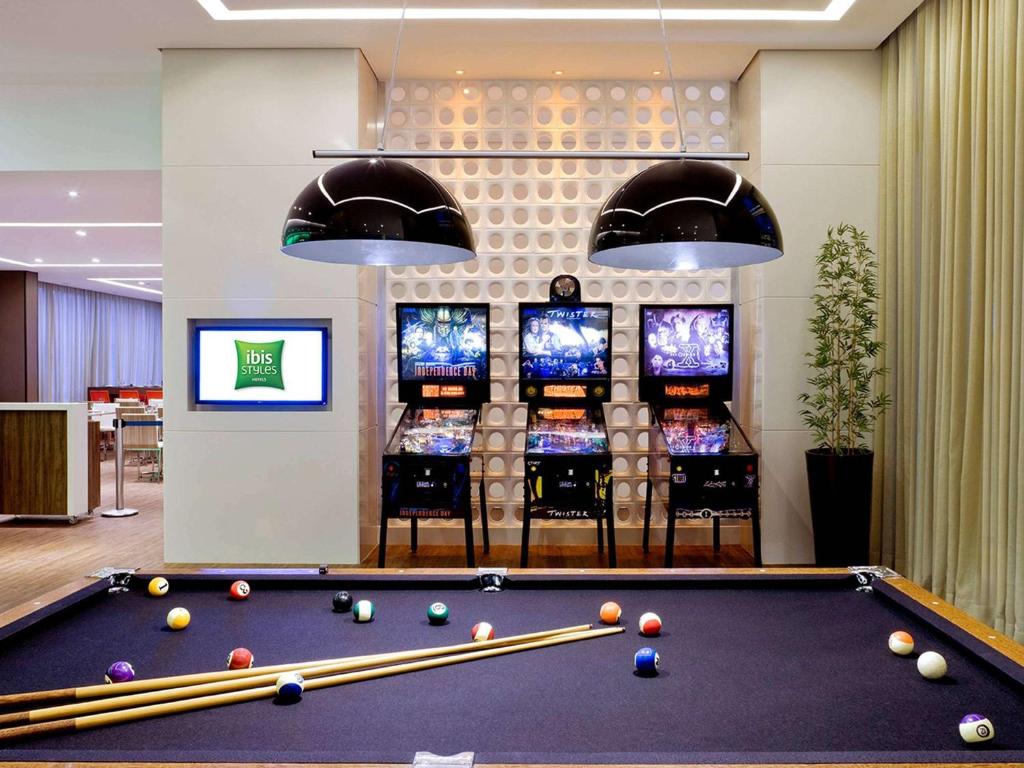 a billiard room with a pool table and several televisions at ibis Styles Brasilia Aeroporto in Brasília