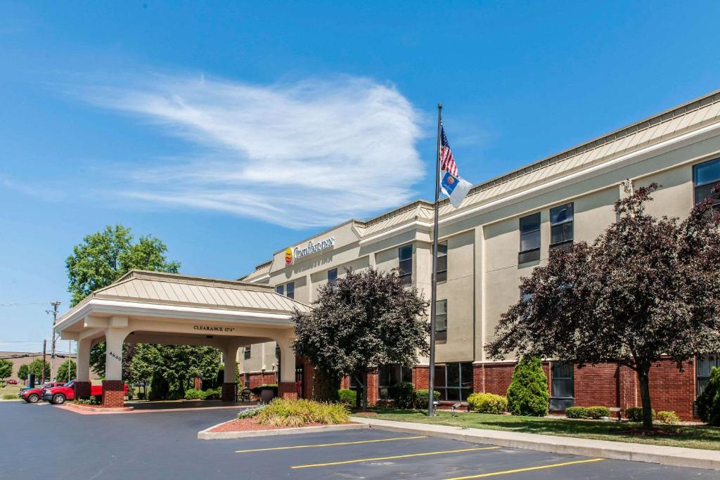 an exterior view of a hotel with an american flag at Comfort Inn Blue Ash North in Blue Ash