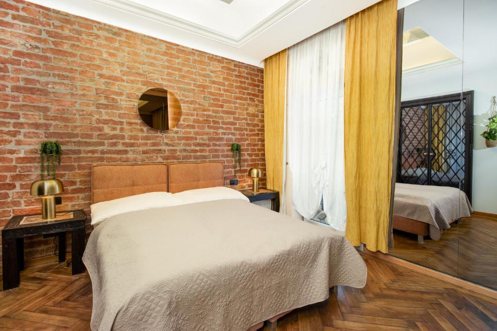 um quarto com uma cama e uma parede de tijolos em Castello Apartments em Viena