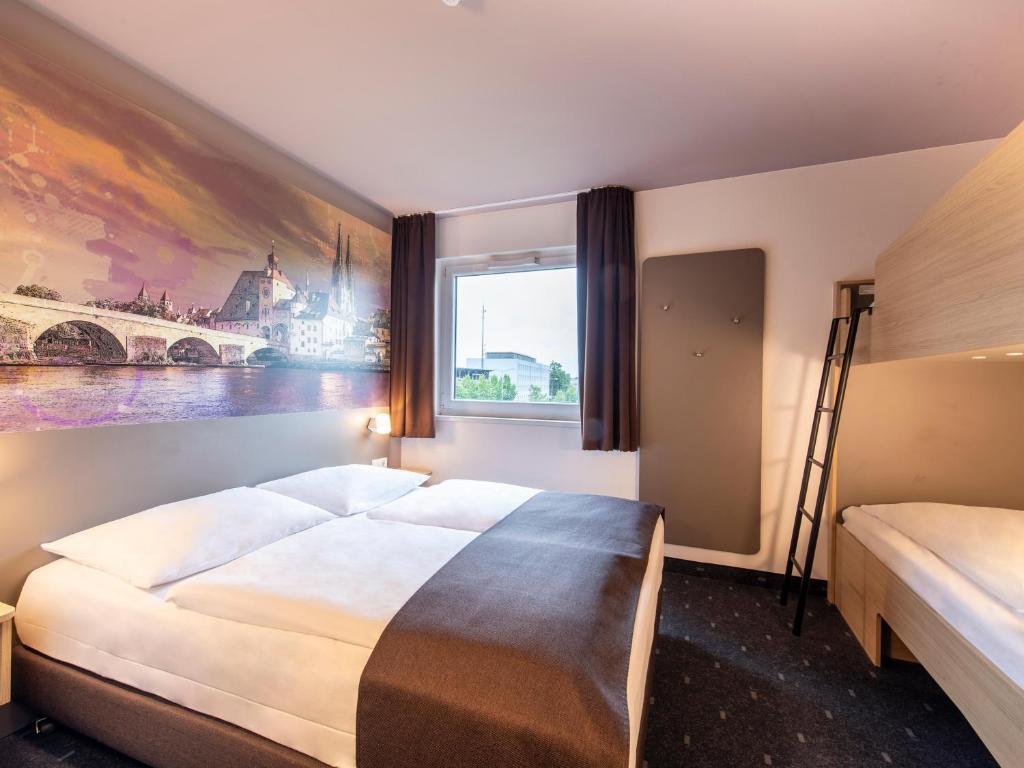 a bedroom with a large bed and a window at B&B Hotel Regensburg-City in Regensburg