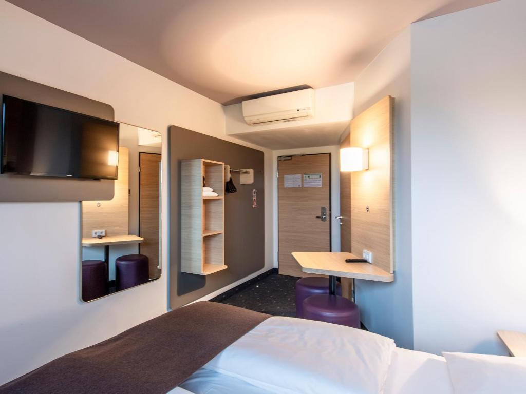 a hotel room with a bed and a desk at B&B Hotel Regensburg-City in Regensburg