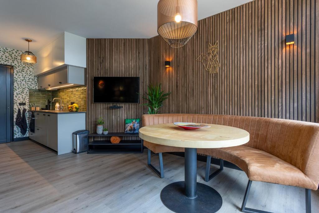 uma sala de estar com uma mesa e uma cozinha em Bed & keuken De Vos em Delden