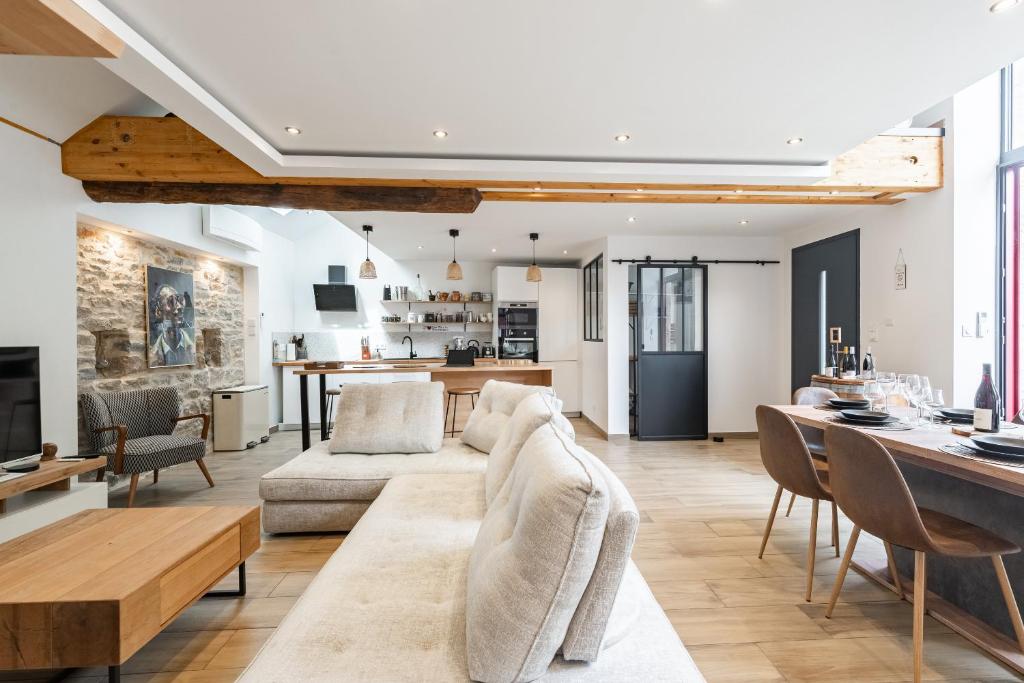 a living room with a couch and a table at Charmante Maison Climatisée avec son Jardin à 10 minutes de DIJON in Marsannay-la-Côte