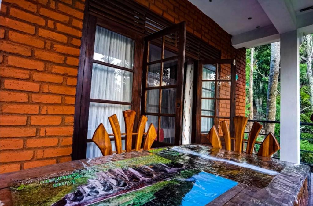 a dining room table with chairs and a brick wall at Ella Rock Glance in Ella