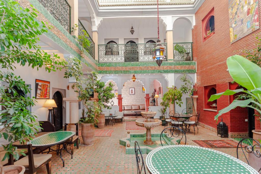 un patio interior con mesas, sillas y plantas en Riad Errabii & Spa, en Marrakech
