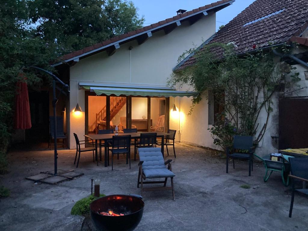 eine Terrasse mit einem Tisch und Stühlen neben einem Gebäude in der Unterkunft Maison de charme in Thil-sur-Arroux