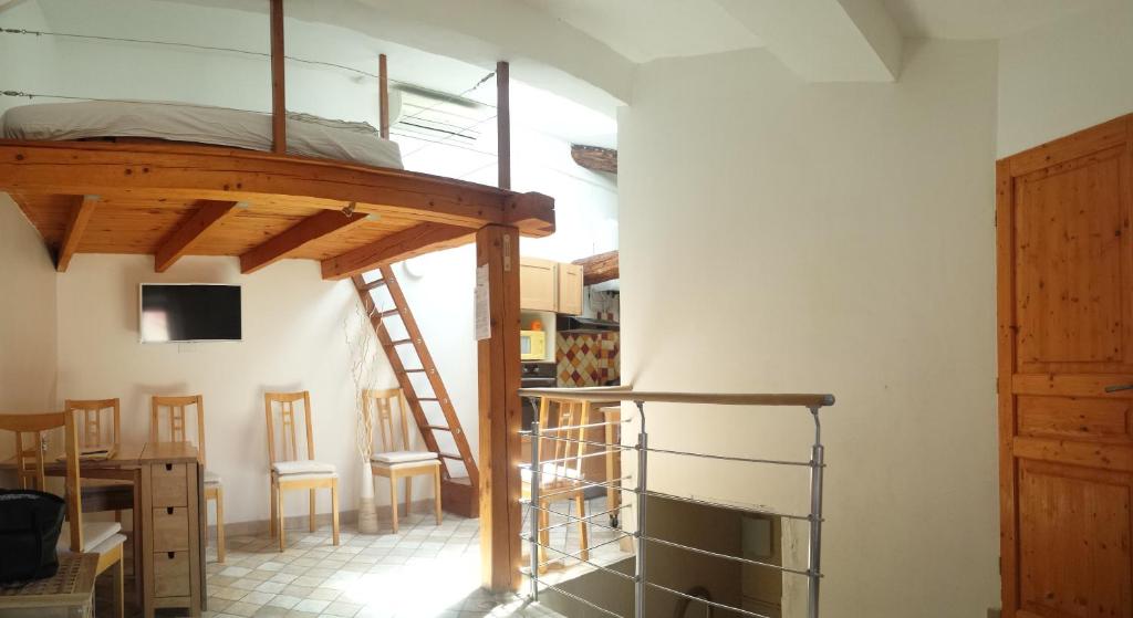 a room with a bunk bed and a table and chairs at Location saisonnière dans le cœur historique – T3 pour 4 à 6 personnes in La Ciotat