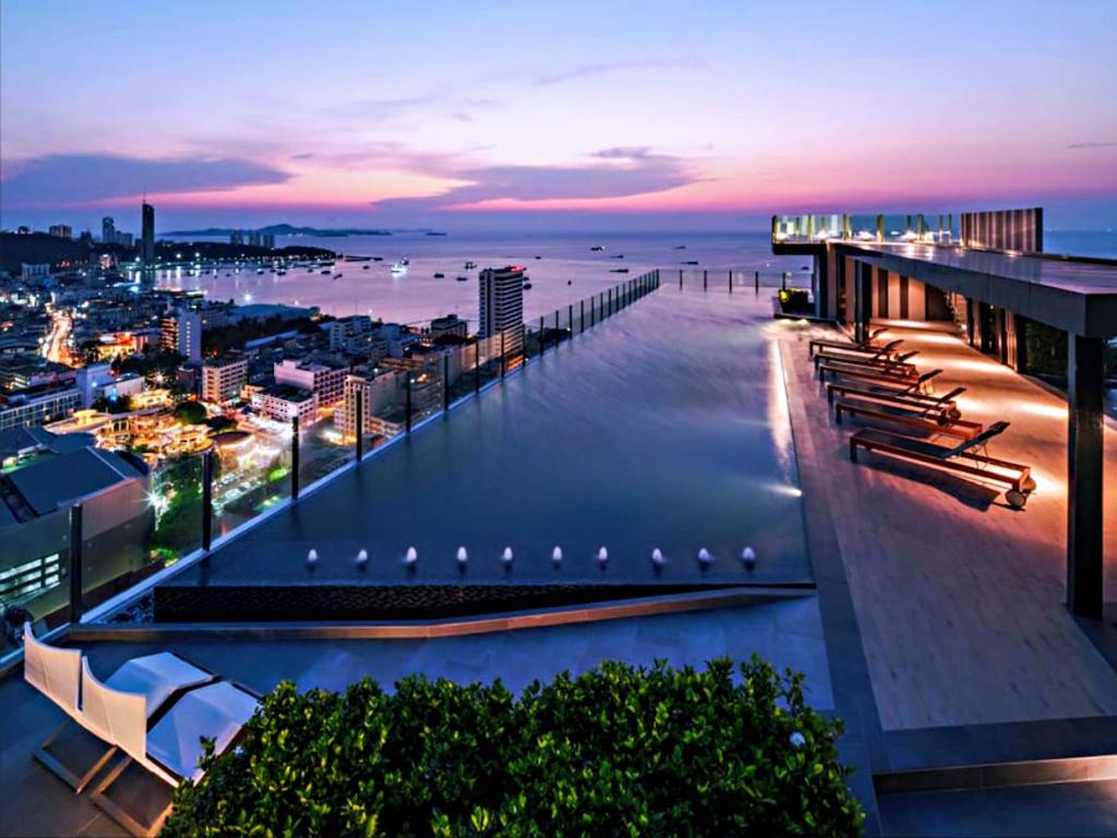 a building with a view of the ocean at night at the base 网红公寓 市中心核心区顶层无边泳池俯瞰整个芭堤雅海湾 in Pattaya