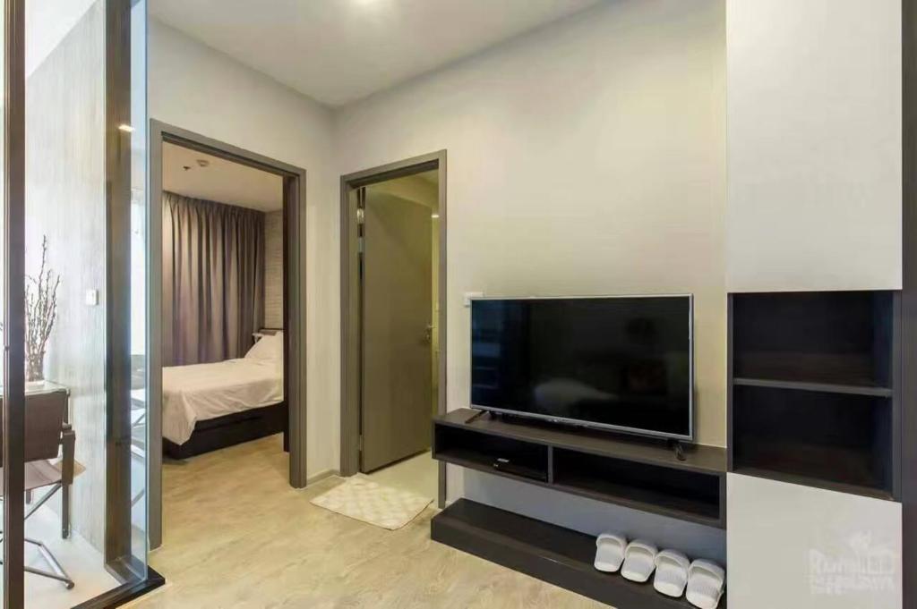 a living room with a television and a bedroom at the base 网红公寓 市中心核心区顶层无边泳池俯瞰整个芭堤雅海湾 in Pattaya