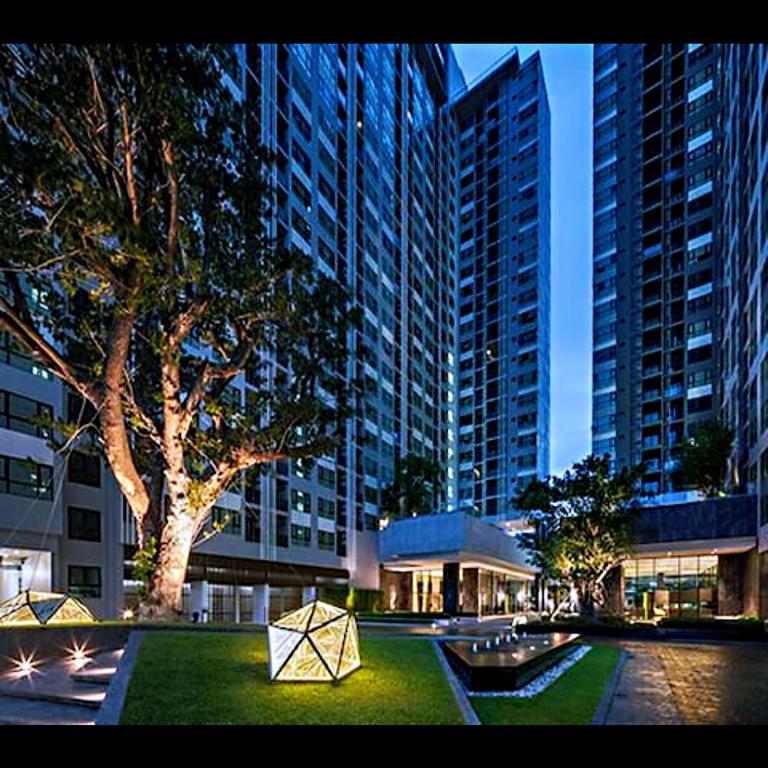 a view of a building with a tree and buildings at the base 网红公寓 市中心核心区顶层无边泳池俯瞰整个芭堤雅海湾 in Pattaya