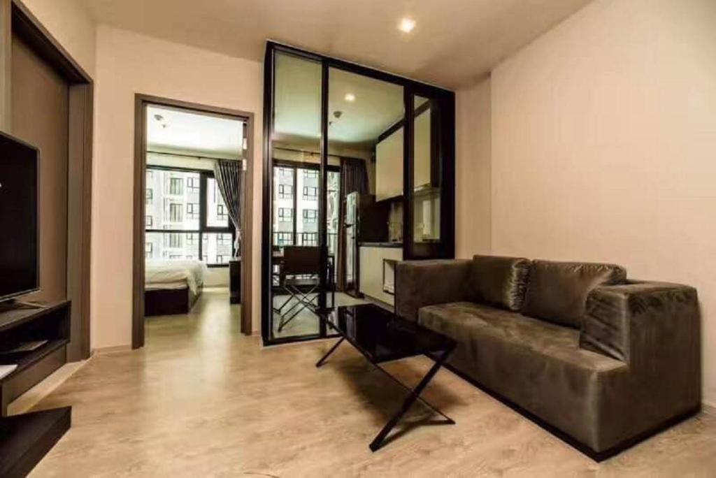 a living room with a couch and a television at the base 网红公寓 市中心核心区顶层无边泳池俯瞰整个芭堤雅海湾 in Pattaya