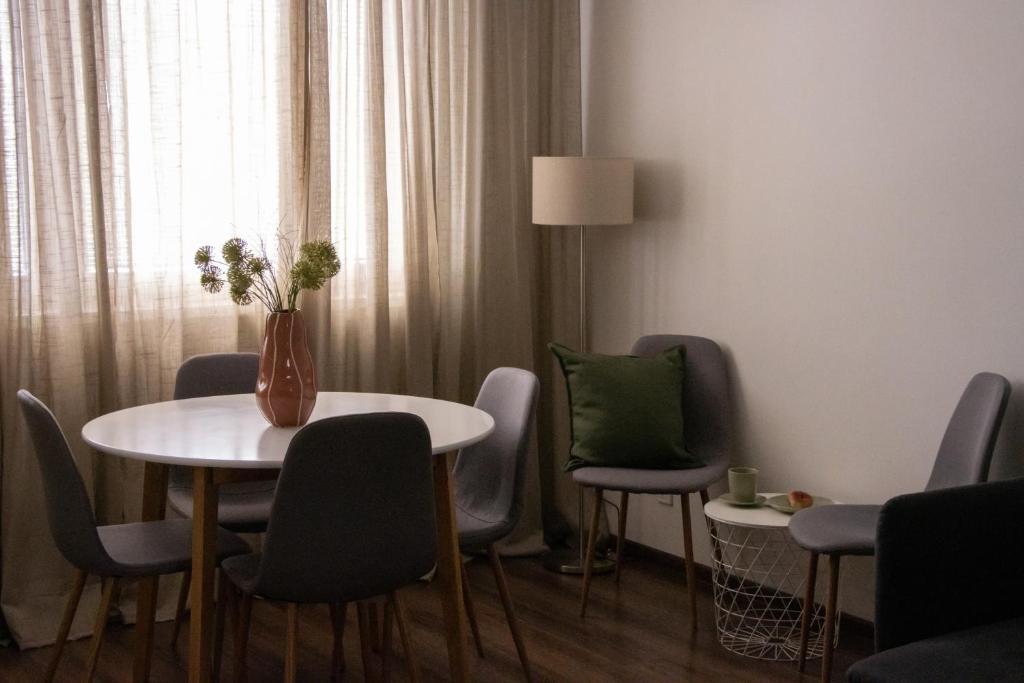 a room with a table and chairs and a vase with flowers at Spacious apartment near the city centre in Bratislava