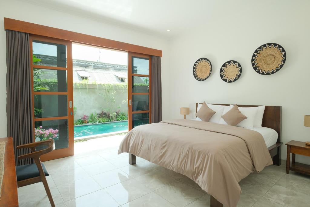 a bedroom with a bed and a large window at Santera Village in Canggu