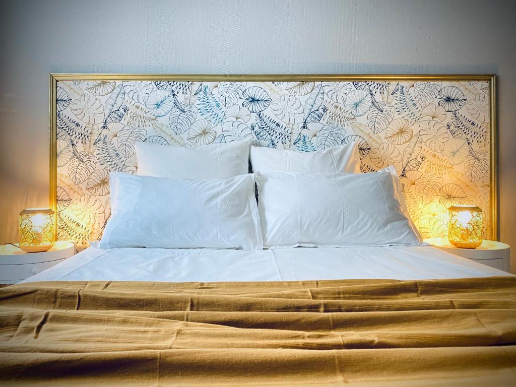 a large bed with white pillows and two lamps at Sweet Cēmoi Retreat au calme, proche gare, Netflix in Grenoble