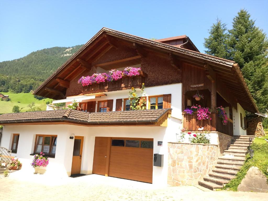 una casa con fiori sui balconi di Haus Simma ad Au im Bregenzerwald