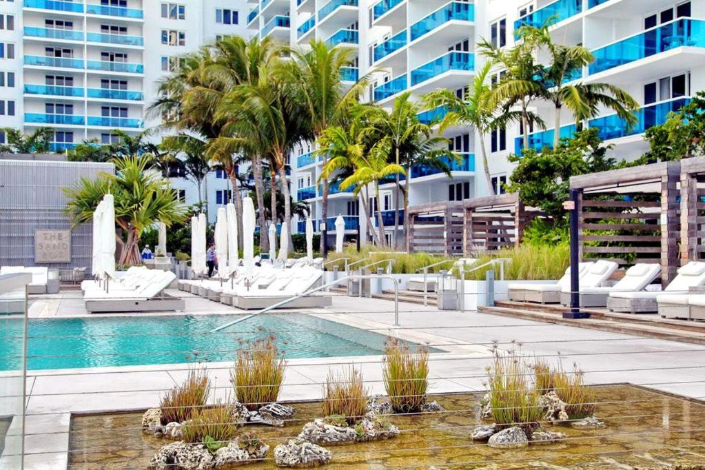 マイアミビーチにあるBA Miami Apartmentsのヤシの木が茂るスイミングプール、建物