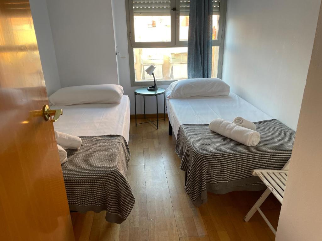 ein kleines Zimmer mit 2 Betten und einem Fenster in der Unterkunft NEW! Amazing 2 bedroom apartment in Rambla del Poblenou in Barcelona