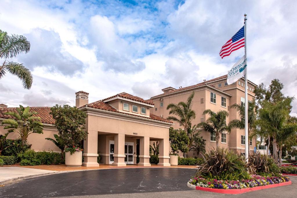 un edificio con una bandera americana delante de él en Homewood Suites by Hilton Oxnard/Camarillo, en Oxnard