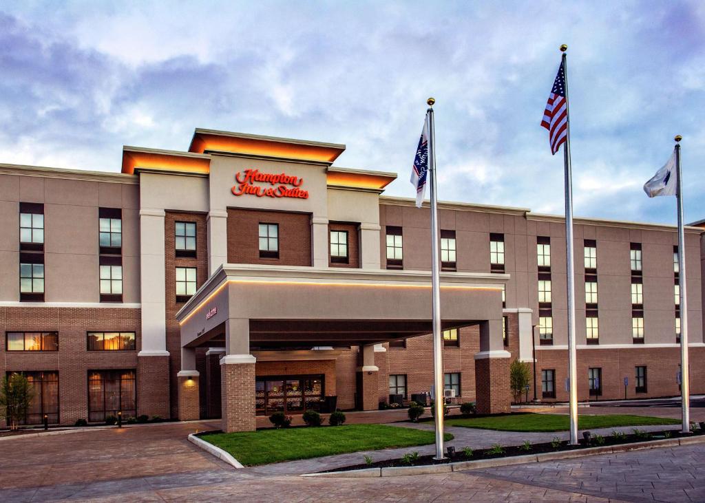 a hotel with two american flags in front of it at Hampton Inn & Suites/Foxborough/Mansfield in Foxborough