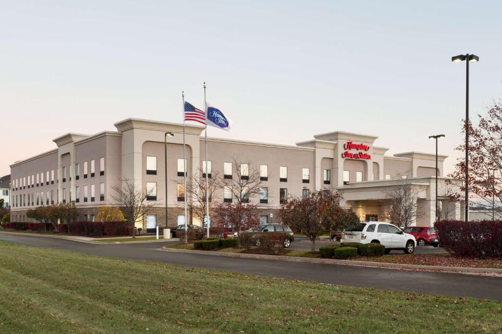 a building with an american flag in front of it at Hampton Inn & Suites Detroit Sterling Heights in Sterling Heights