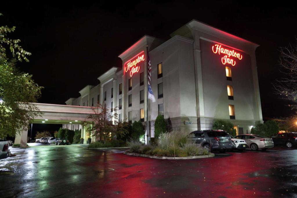 a hotel with neon signs in a parking lot at Hampton Inn Oneonta in Oneonta