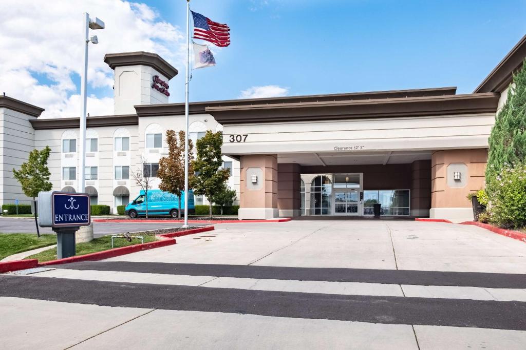 un edificio con una bandera americana delante de él en Hampton Inn & Suites Salt Lake City Airport, en Salt Lake City