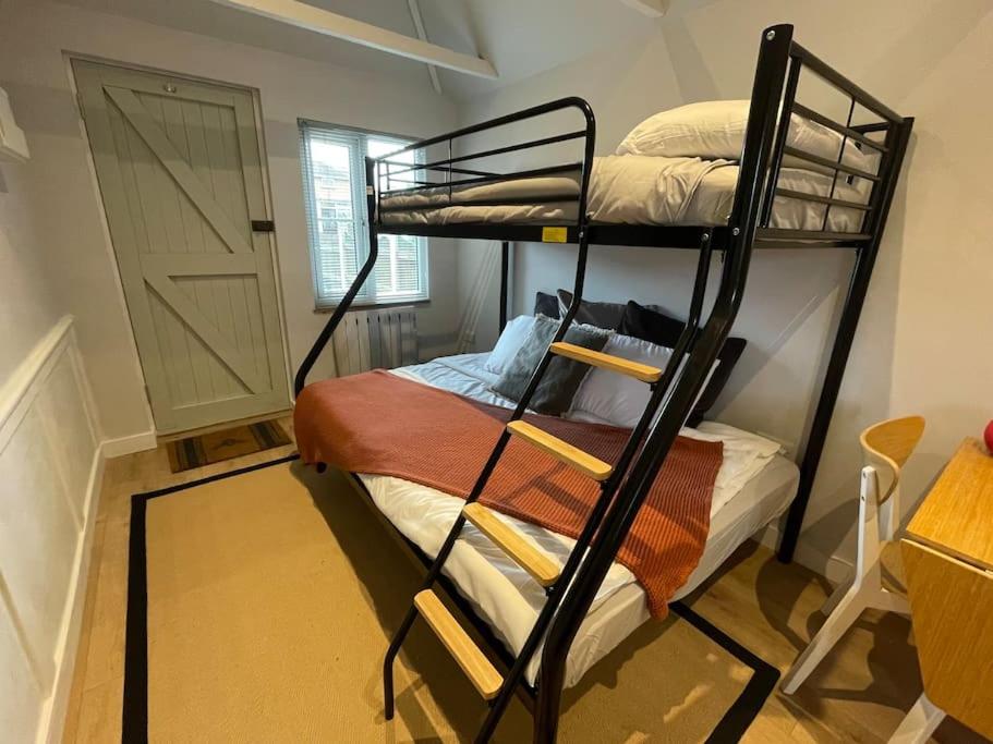 a room with two bunk beds and a door at Merryfield Lodge in Kent