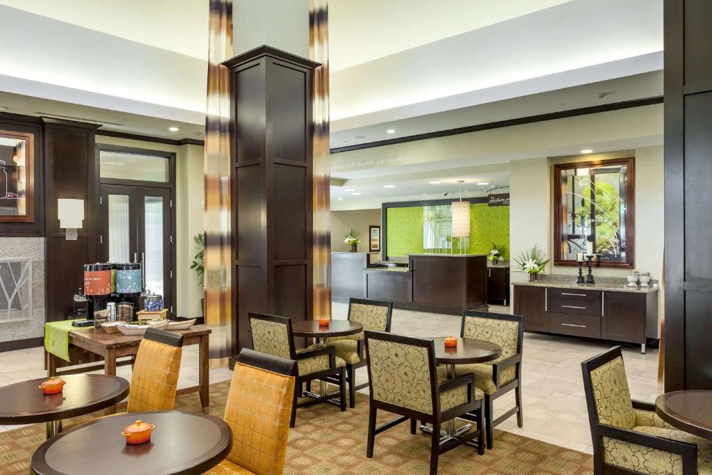 un hall avec des tables et des chaises ainsi qu'une cuisine dans l'établissement Hilton Garden Inn Eugene/Springfield, à Springfield