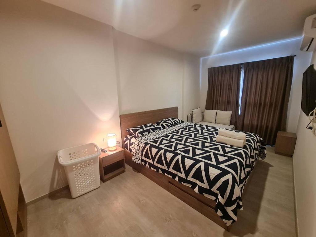 een slaapkamer met een zwart-wit bed en een raam bij Lacasita Penthouse Nap in Hua Hin