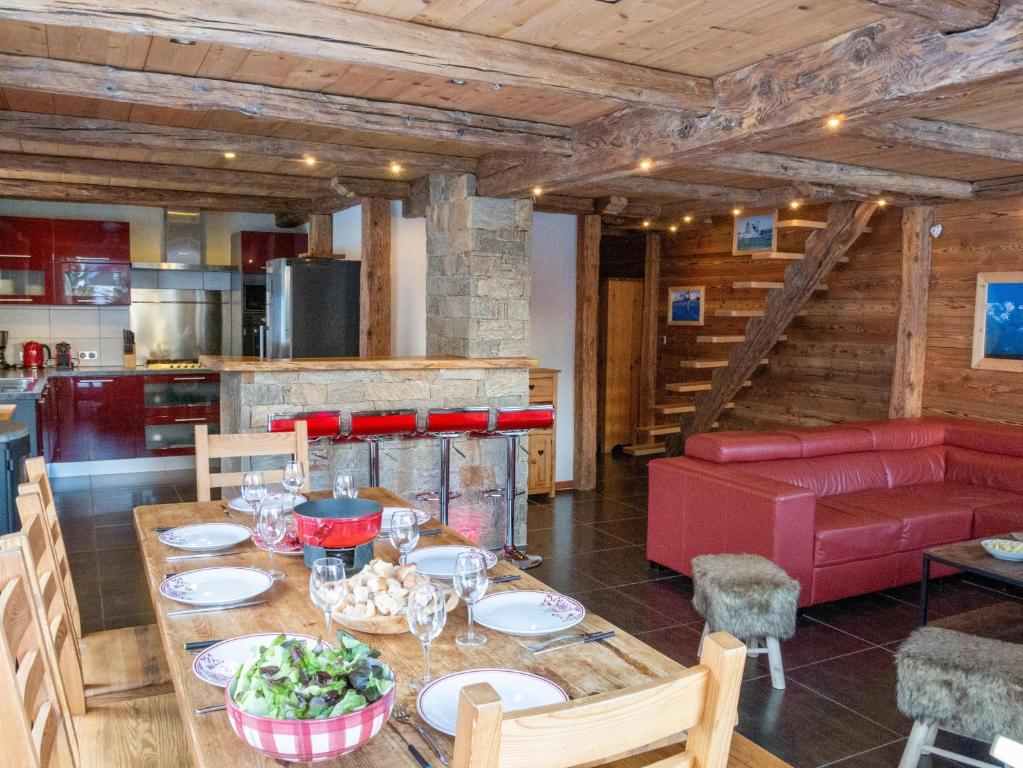 a dining room with a table and a red couch at L'Ecrin des Granges - La Cime in Villarembert