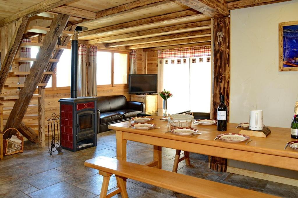 a living room with a table and a wood stove at L'Ecrin des Granges-Le Roc in Villarembert