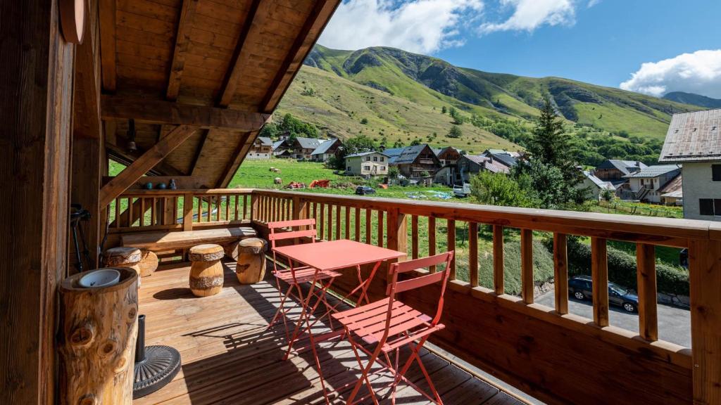 a deck with a table and chairs and mountains at Les Aiguilles 201 - sublime Appt - 7 pers in Saint-Sorlin-dʼArves