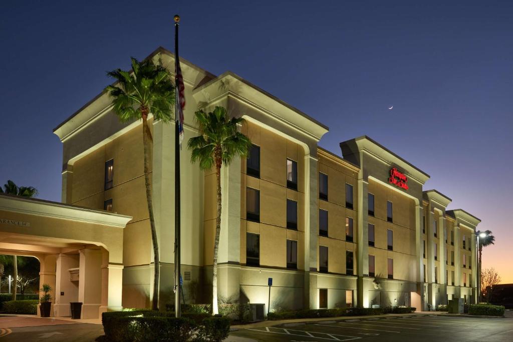 un hôtel avec des palmiers devant un bâtiment dans l'établissement Hampton Inn & Suites Port St. Lucie, à Port Sainte-Lucie